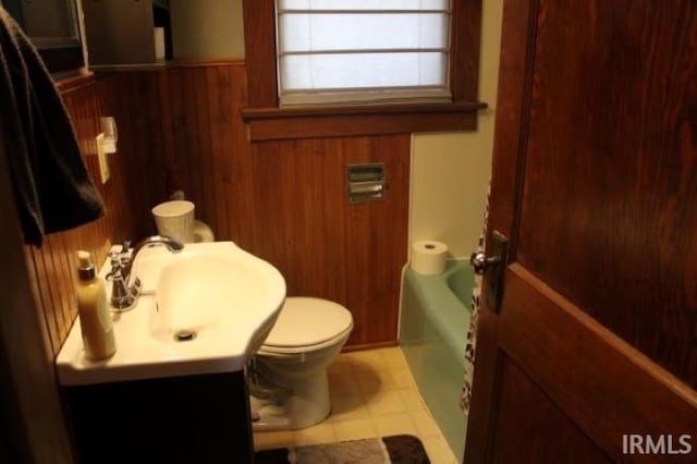 full bathroom featuring tile patterned floors, toilet, wooden walls, vanity, and shower with separate bathtub