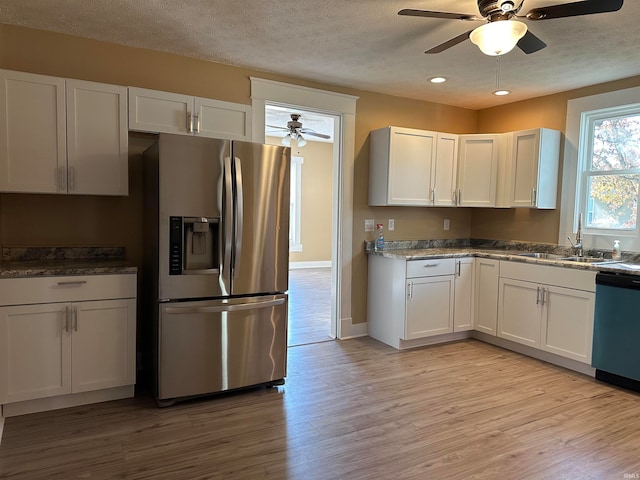 kitchen featuring white cabinetry, stainless steel appliances, sink, and light wood-type flooring