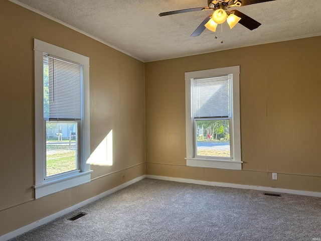 carpeted spare room featuring ceiling fan and a textured ceiling