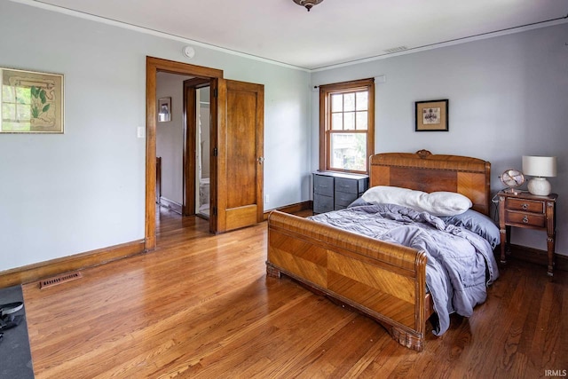 bedroom featuring hardwood / wood-style flooring and crown molding