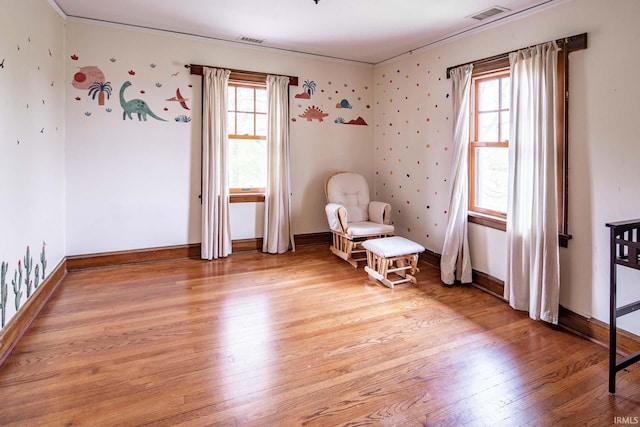 unfurnished room with plenty of natural light, light wood-type flooring, and crown molding