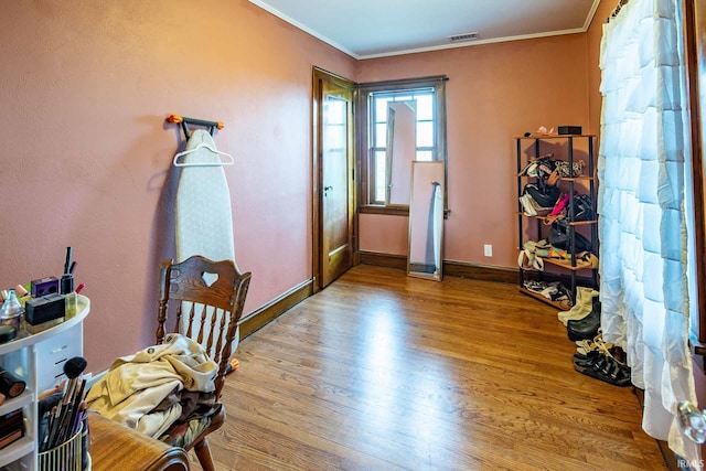 entryway featuring ornamental molding and light hardwood / wood-style flooring