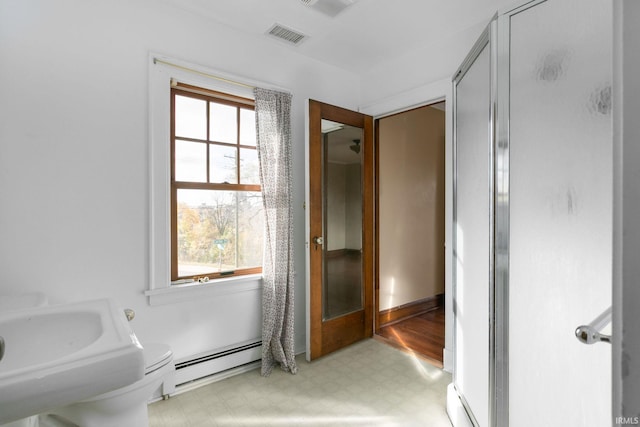 bathroom featuring a wealth of natural light and baseboard heating