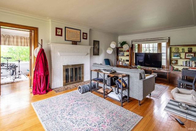 living room featuring a fireplace, wood-type flooring, and crown molding