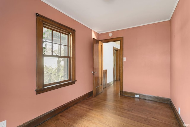 empty room featuring hardwood / wood-style floors and ornamental molding