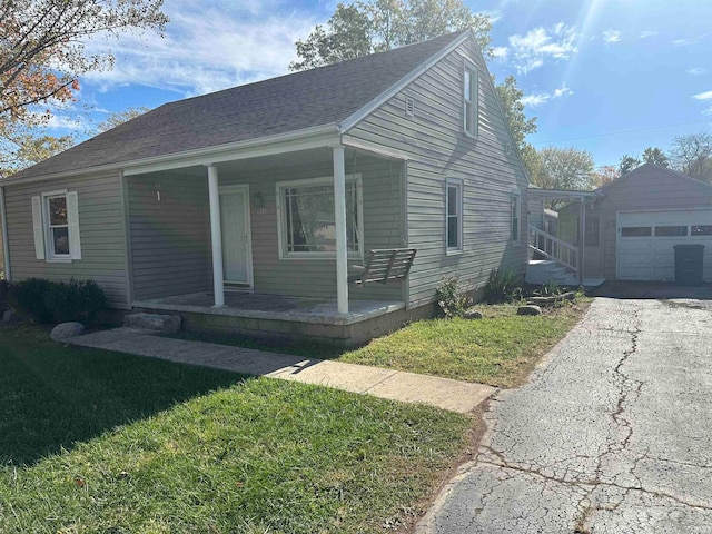 bungalow-style home with a front yard, an outdoor structure, a porch, and a garage