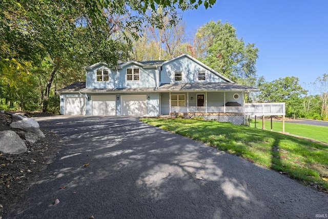 view of front facade featuring a front yard, a porch, and a garage