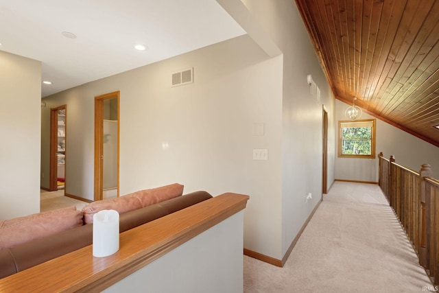 hallway featuring wooden ceiling, vaulted ceiling, and light colored carpet