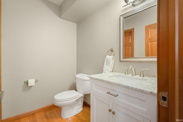 bathroom with vanity, toilet, and hardwood / wood-style flooring