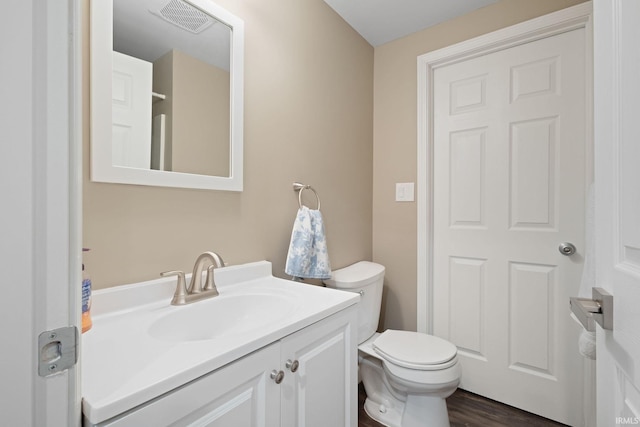 bathroom with vanity, toilet, and wood-type flooring