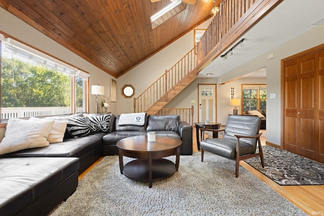 living room featuring wood ceiling, lofted ceiling with skylight, wood-type flooring, and plenty of natural light