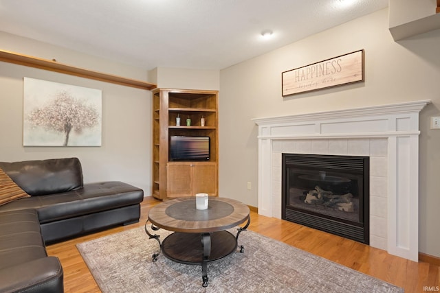 living room with light hardwood / wood-style floors and a tile fireplace