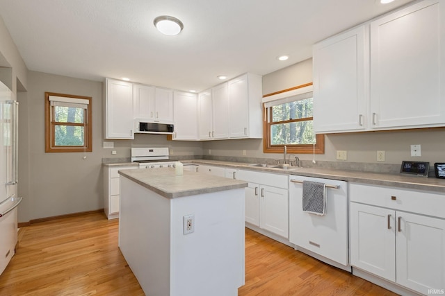 kitchen featuring white appliances, extractor fan, and white cabinets