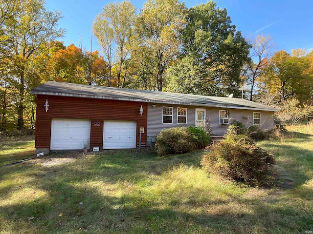 view of front of property with cooling unit, a garage, and a front lawn