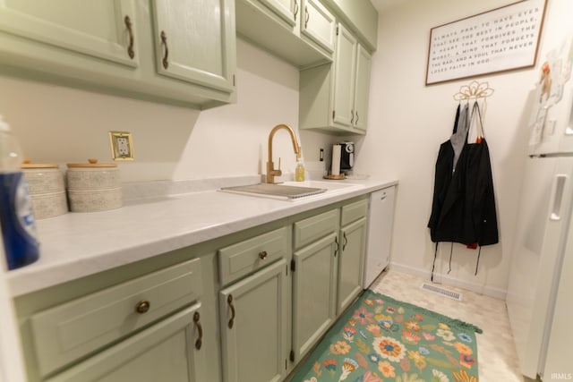 kitchen featuring sink, green cabinets, and white appliances