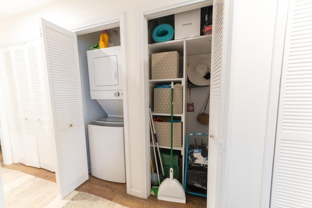 washroom with light hardwood / wood-style flooring and stacked washer and clothes dryer