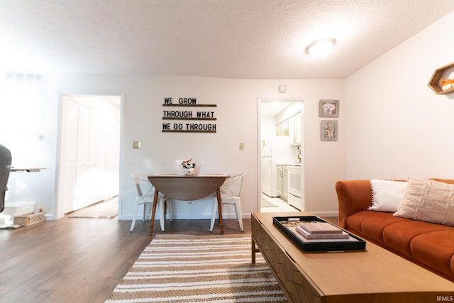 living room with a textured ceiling and dark hardwood / wood-style floors