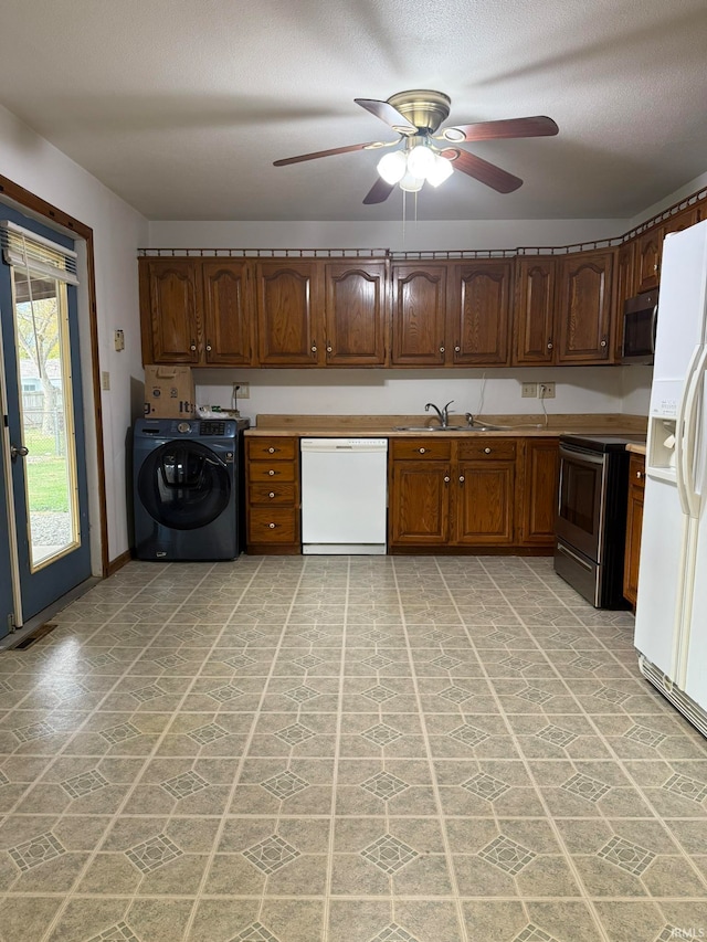 kitchen featuring washer / dryer, ceiling fan, appliances with stainless steel finishes, a textured ceiling, and sink