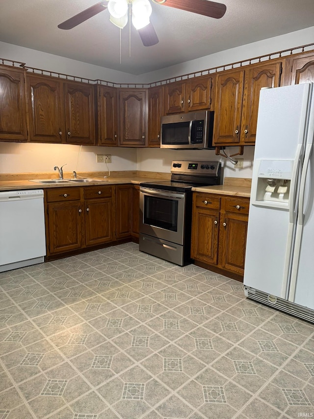 kitchen with sink, appliances with stainless steel finishes, and ceiling fan