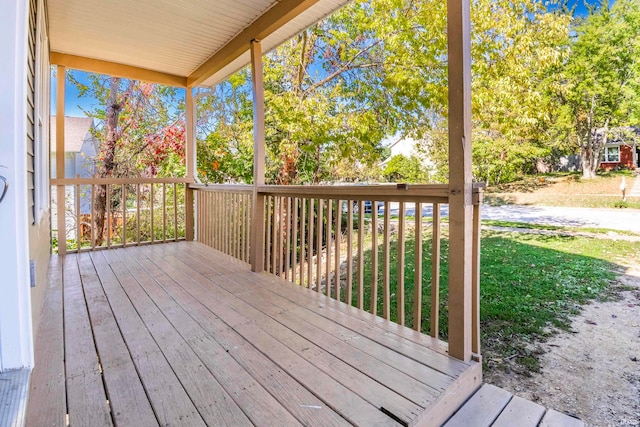 wooden terrace featuring a lawn