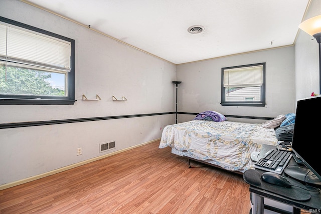 bedroom featuring light hardwood / wood-style floors and crown molding