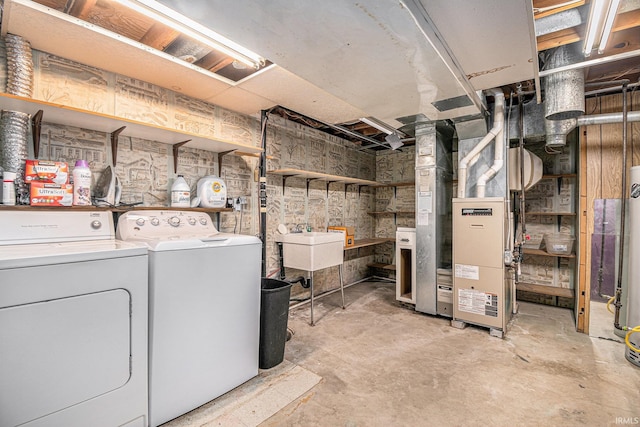 basement featuring sink, heating unit, and separate washer and dryer