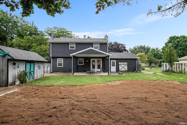 rear view of property featuring a patio, a storage shed, and a yard