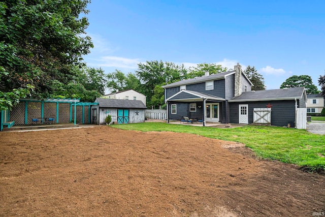 back of house featuring a patio, a shed, and a yard