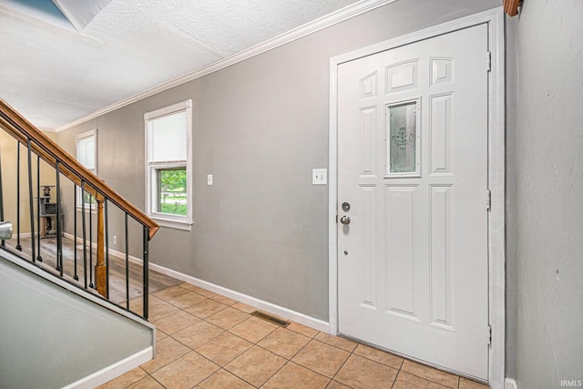 foyer entrance featuring crown molding and light tile patterned floors