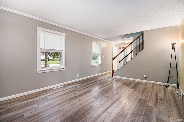 spare room with crown molding, hardwood / wood-style floors, and a textured ceiling