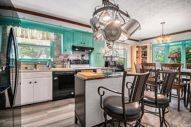 kitchen with butcher block counters, black dishwasher, a healthy amount of sunlight, and stove