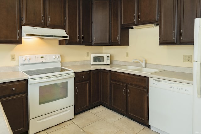 kitchen featuring light tile patterned floors, white appliances, dark brown cabinetry, and sink