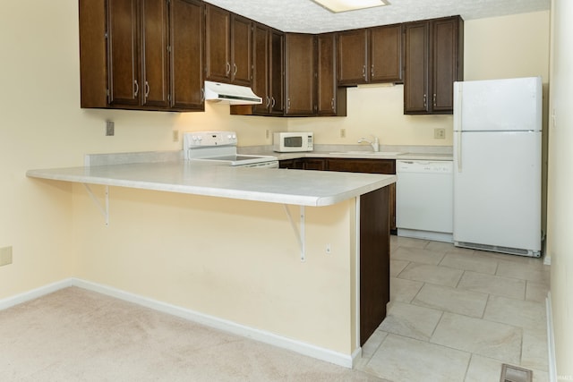 kitchen featuring kitchen peninsula, a breakfast bar, and white appliances