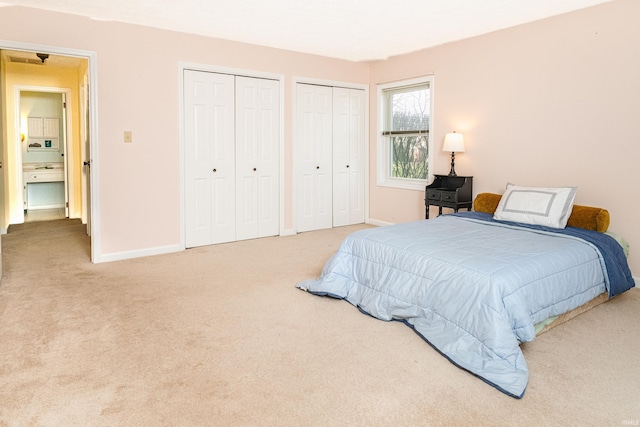 bedroom featuring multiple closets and carpet floors