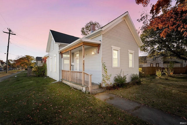 property exterior at dusk featuring a lawn