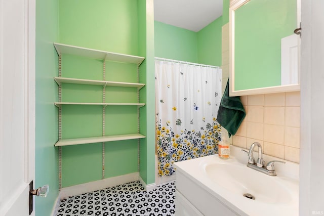 bathroom with vanity, walk in shower, and backsplash