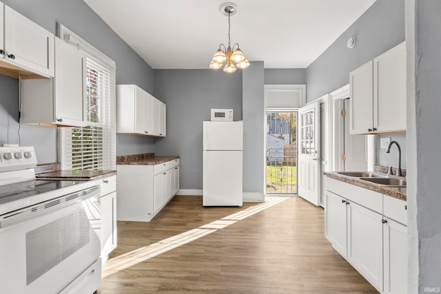 kitchen featuring white appliances, light wood-type flooring, white cabinetry, and plenty of natural light