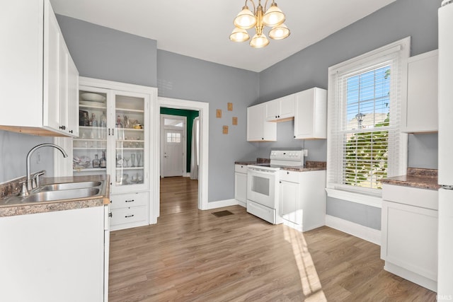 kitchen with white cabinetry, sink, a wealth of natural light, and electric stove