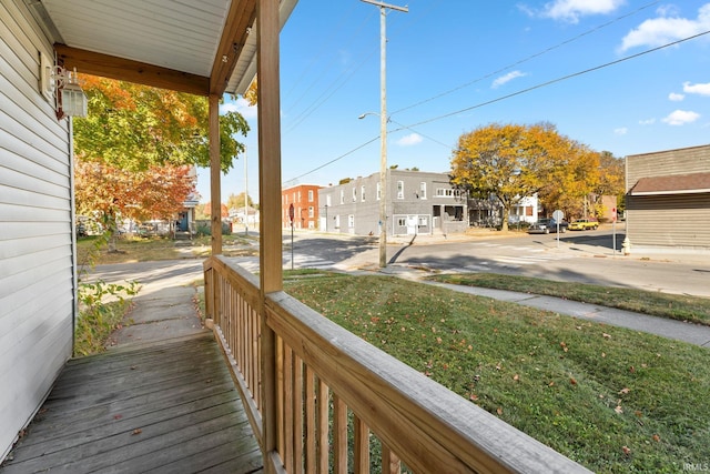 wooden terrace with covered porch and a lawn