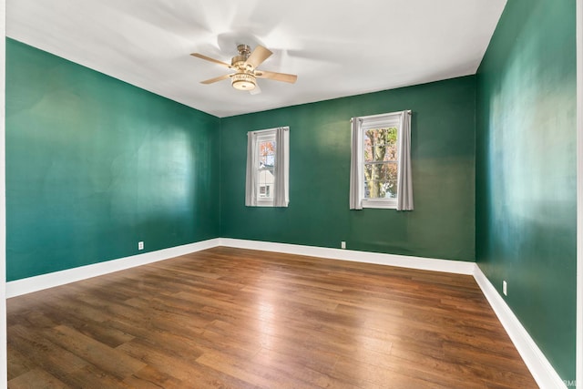 empty room featuring dark wood-type flooring and ceiling fan