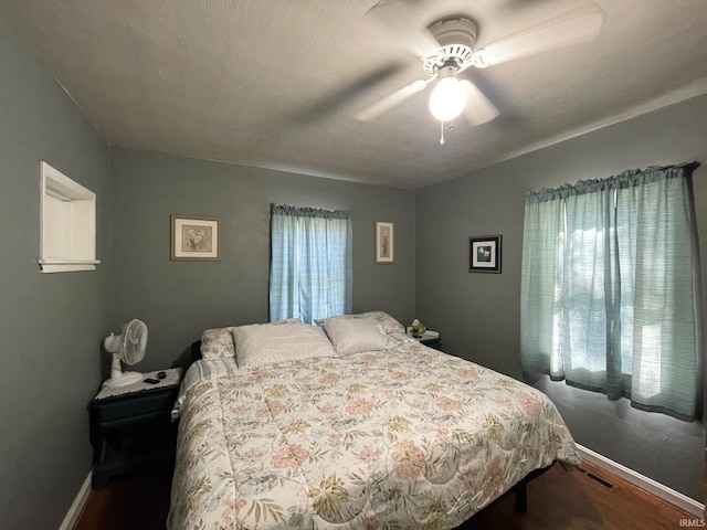 bedroom with hardwood / wood-style floors, a textured ceiling, and ceiling fan