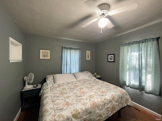 bedroom with baseboards, ceiling fan, and wood finished floors