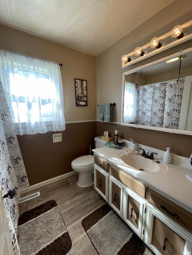 full bath featuring wood finished floors, curtained shower, vanity, baseboards, and toilet