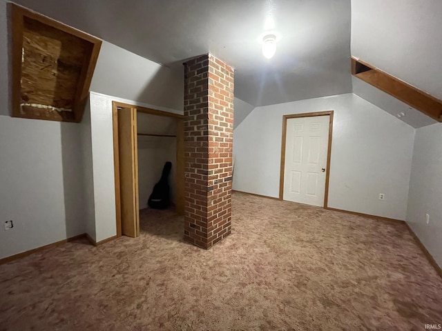 additional living space featuring carpet floors, decorative columns, and vaulted ceiling