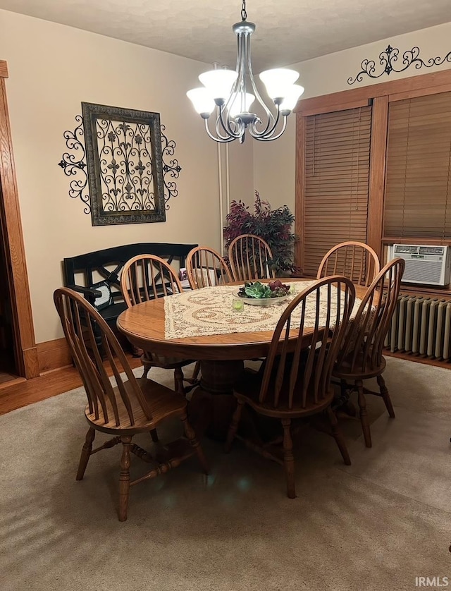 dining space featuring cooling unit, radiator heating unit, a chandelier, and carpet flooring