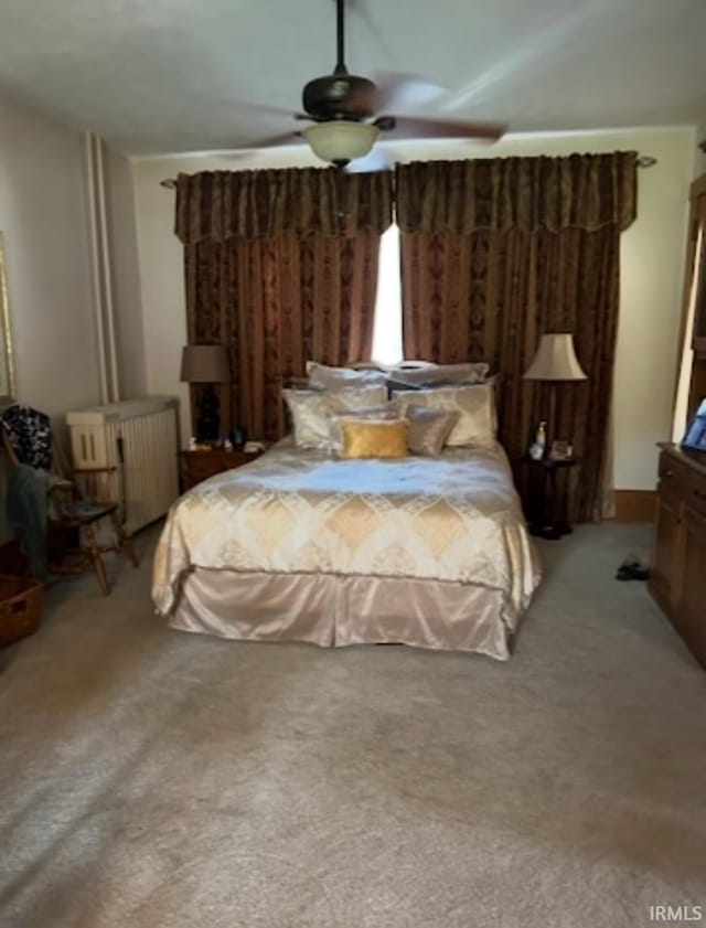 carpeted bedroom featuring ceiling fan and radiator heating unit