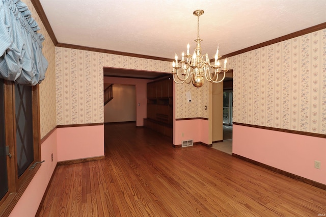 unfurnished dining area with crown molding, a notable chandelier, and dark hardwood / wood-style floors