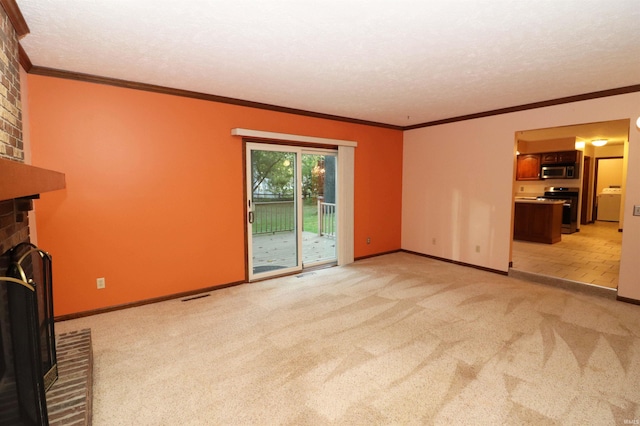 unfurnished living room featuring washer / dryer, a textured ceiling, a brick fireplace, crown molding, and light colored carpet