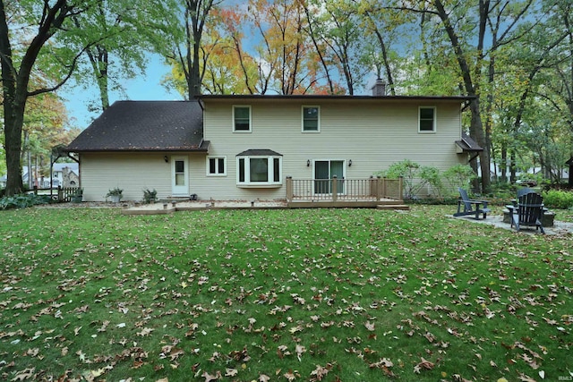 rear view of house with a deck and a lawn