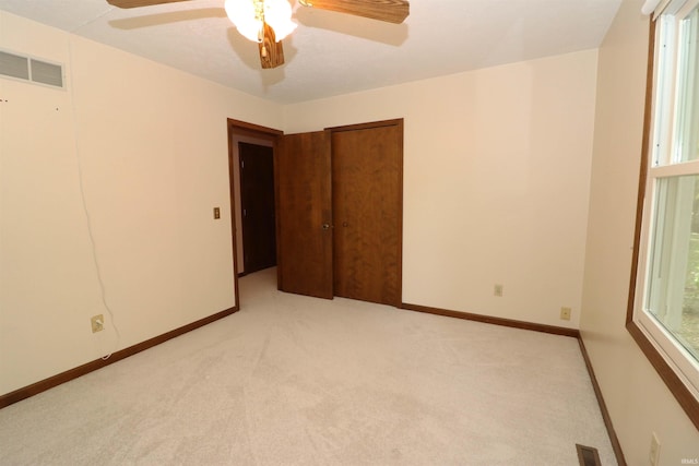 unfurnished bedroom with light colored carpet and ceiling fan